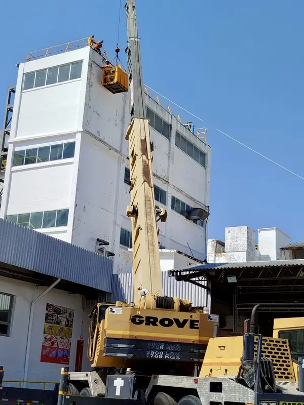 Grúa Grove izando un equipo en la cubierta de una planta